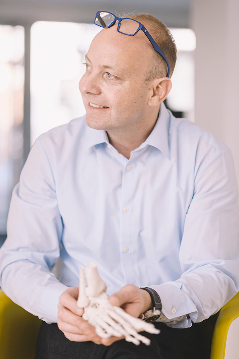Tom Huber hält ein Fussskelet in den Händen.